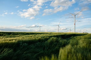 beautiful-grassy-field-with-windmills-distance-blue-sky (1)